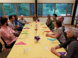 Intergenerational adults gathered around a table for the inaugural FEAST dinner conversation in 2018